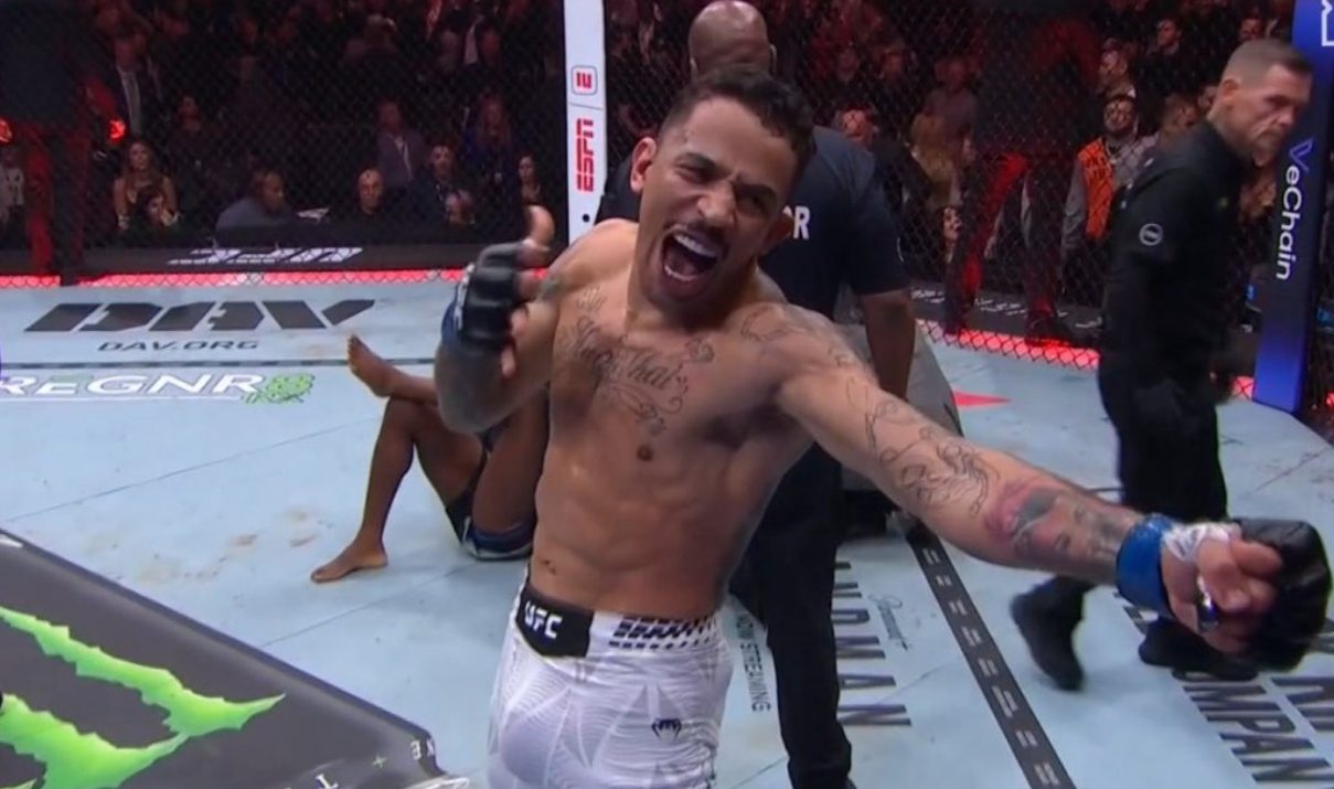 Tattooed UFC fighter Carlos Prates shouts and celebrates his victory inside the octagon after a fight.