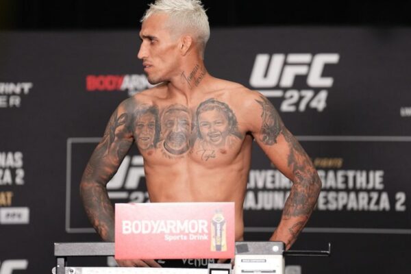 Charles do Bronx, com cabelo loiro e corpo tatuado, na balança durante a pesagem oficial do UFC 274.