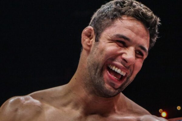 A close-up of MMA fighter Marcus "Buchecha" Almeida laughing joyfully, with his cauliflower ear visible.