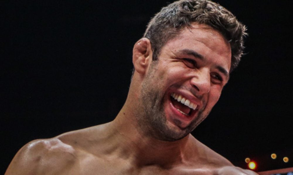 A close-up of MMA fighter Marcus "Buchecha" Almeida laughing joyfully, with his cauliflower ear visible.
