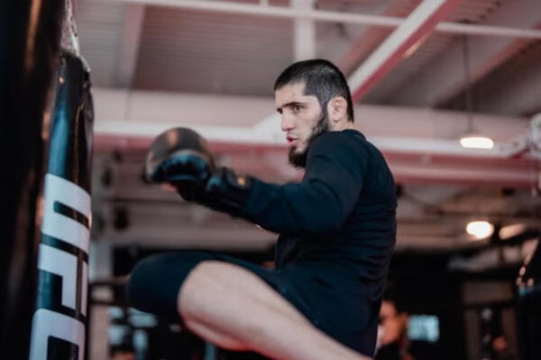 UFC fighter Islam Makhachev throws a knee strike at a UFC punching bag during a training session.