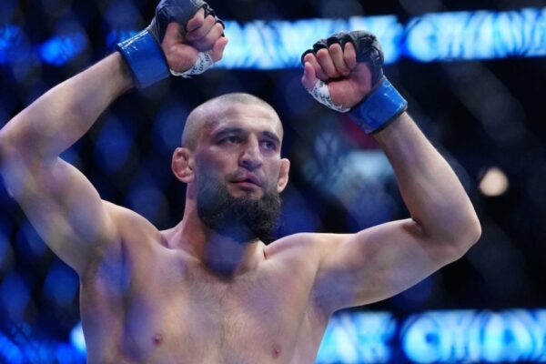 Lutador do UFC Khamzat Chimaev celebra com os punhos erguidos no octógono.