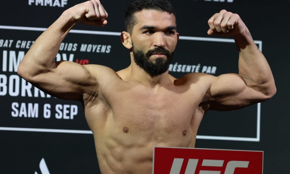O lutador Nassourdine Imavov, sem camisa, flexiona os músculos na pesagem oficial do UFC.