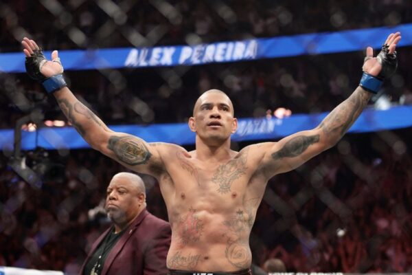 O lutador do UFC Alex Poatan comemora a vitória com os braços erguidos no octógono.