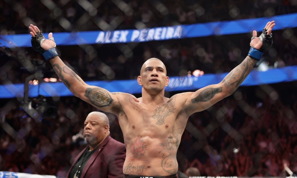 O lutador do UFC Alex Poatan comemora a vitória com os braços erguidos no octógono.