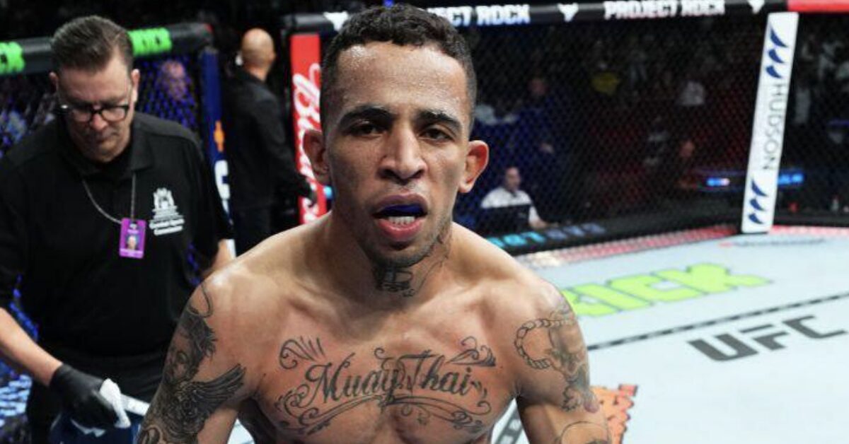 UFC fighter Carlos Prates with a "Muay Thai" chest tattoo stares intensely forward inside the octagon.