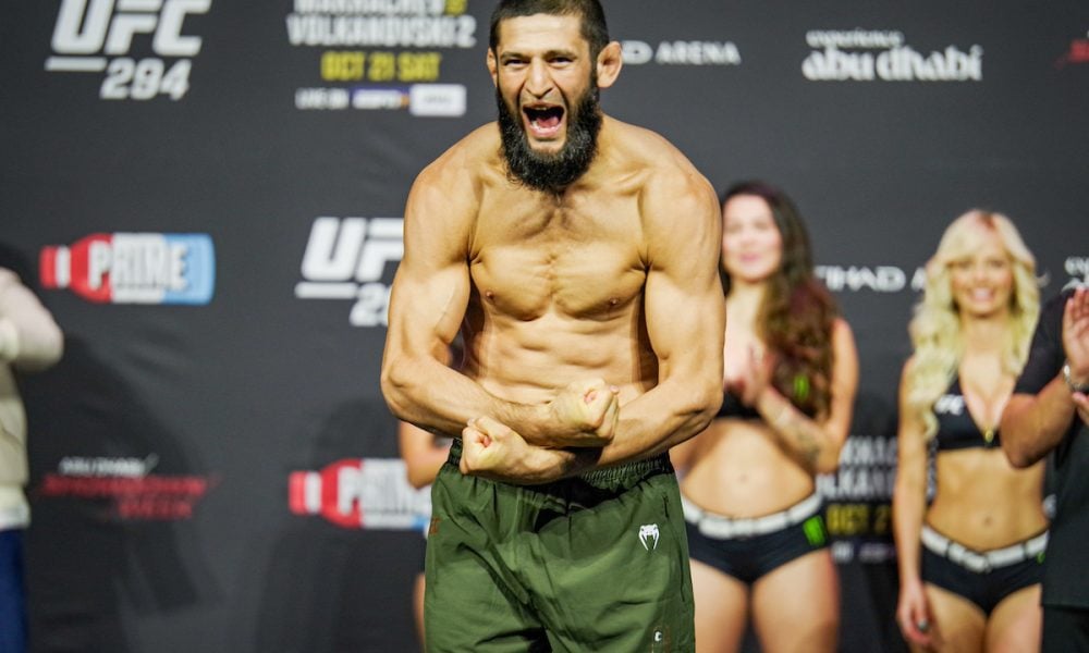 A bearded Khamzat Chimaev roars and flexes his muscular physique on stage at the UFC 294 weigh-in.