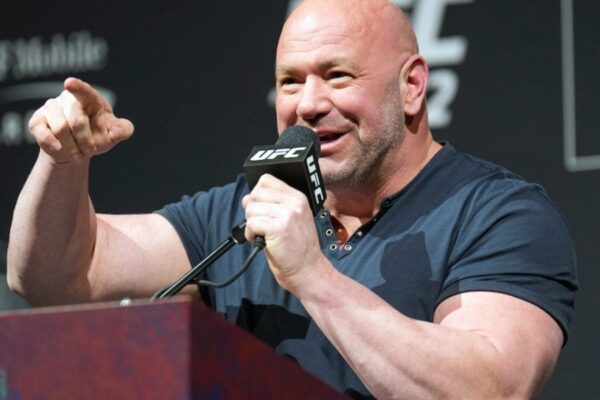 Presidente do UFC, Dana White sorri e aponta com o dedo enquanto fala ao microfone em coletiva.