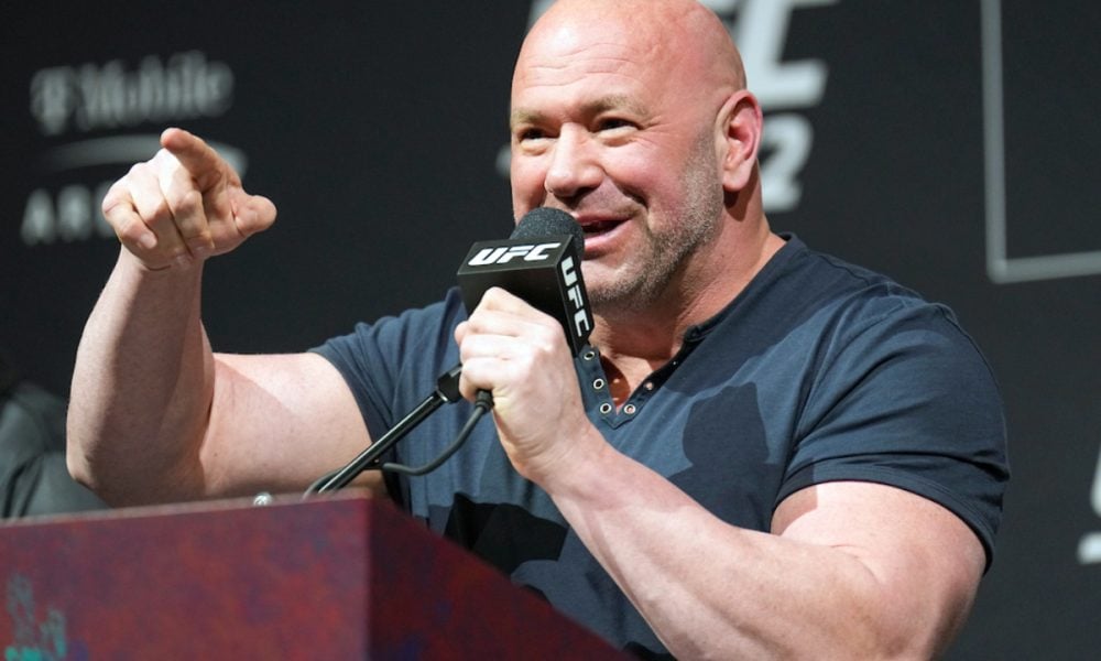 Presidente do UFC, Dana White sorri e aponta com o dedo enquanto fala ao microfone em coletiva.