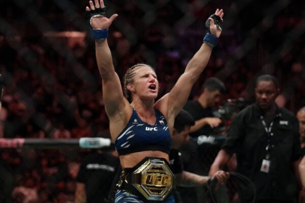 Lutadora do UFC, Kayla Harrison comemora o título com o cinturão e os braços erguidos.