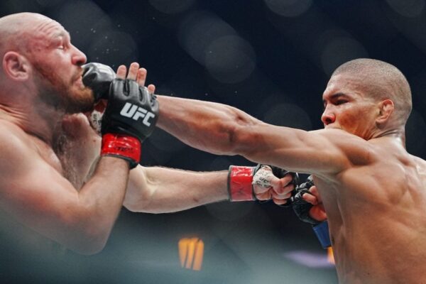 A UFC fighter lands a powerful punch to his opponent's face during an intense MMA match.