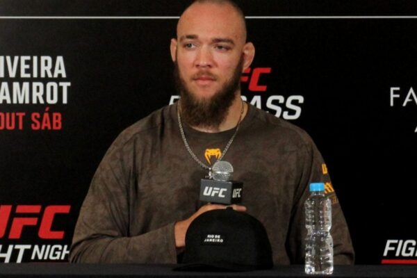 Lutador Valter Walker em coletiva de imprensa do UFC Rio, sentado em frente a um backdrop do evento.