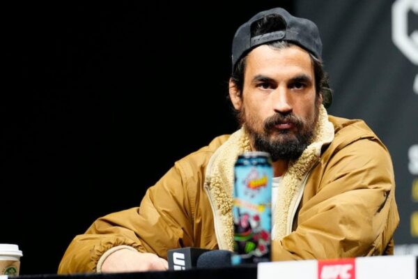 O lutador Kron Gracie, de boné e jaqueta, encara a câmera durante uma coletiva de imprensa do UFC.