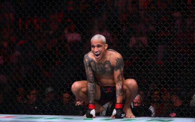 O lutador do UFC Charles do Bronx, de cabelo platinado, agachado no octógono com uma expressão intensa.