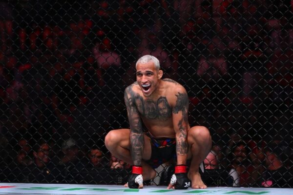 O lutador do UFC Charles do Bronx, de cabelo platinado, agachado no octógono com uma expressão intensa.