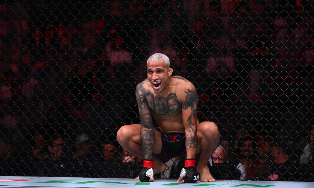 O lutador do UFC Charles do Bronx, de cabelo platinado, agachado no octógono com uma expressão intensa.